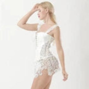 A woman modeling a white lace corset-style lingerie dress against a plain white studio background.